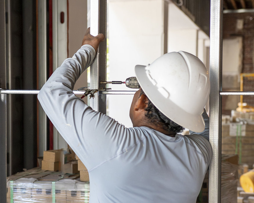 Crew secures the bracing bar between wall studs.