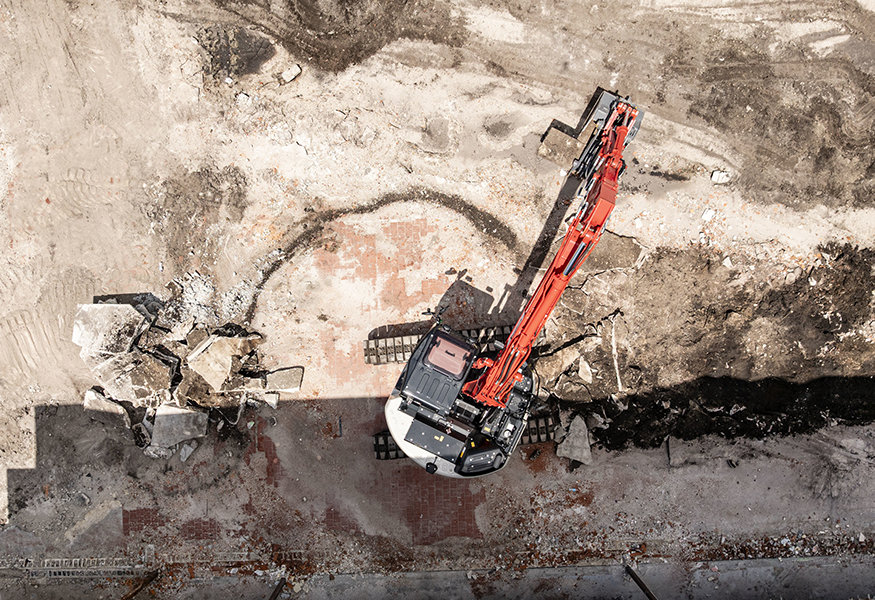 Aerial view of excavator removing floor materials.