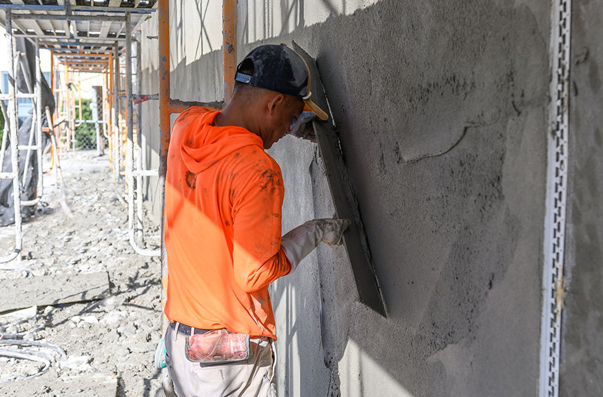 Crew members applying stucco to the south side wall.