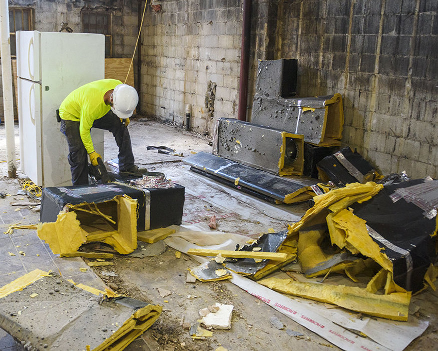 A crew member with the dismantled ductwork