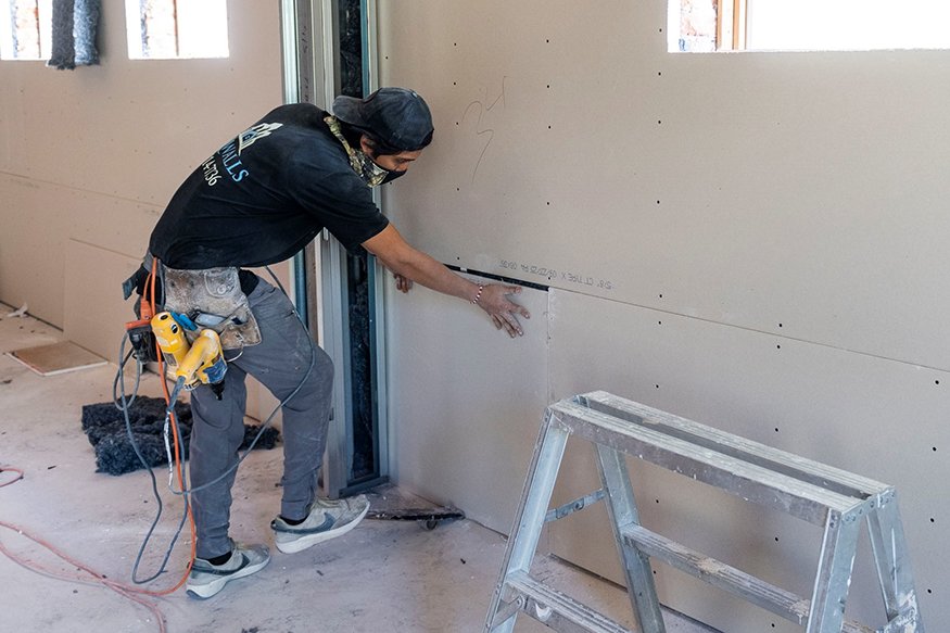 Drywall installation in lower wall area.