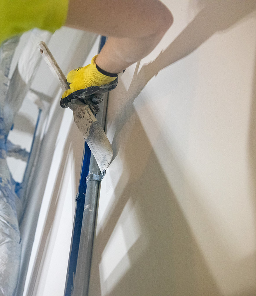 Crew paints interior walls during restoration project. 