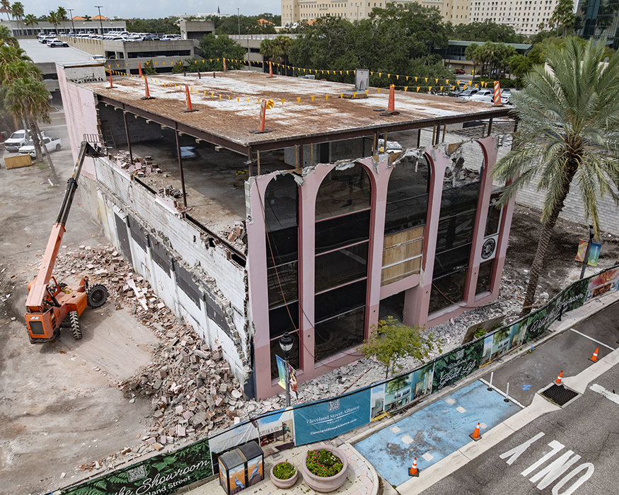 Aerial view of east wall demolition revealing building framework.
