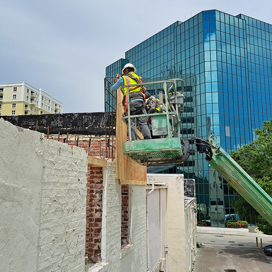 Construction crew is installing formwork for the new parapet beam.