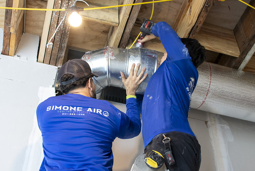 Installing heating and air conditioning systems inside building.