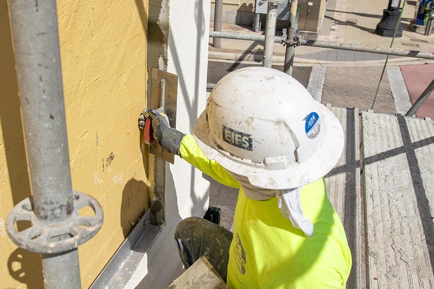 A trowel is used to apply the stucco-like material to the recessed areas.