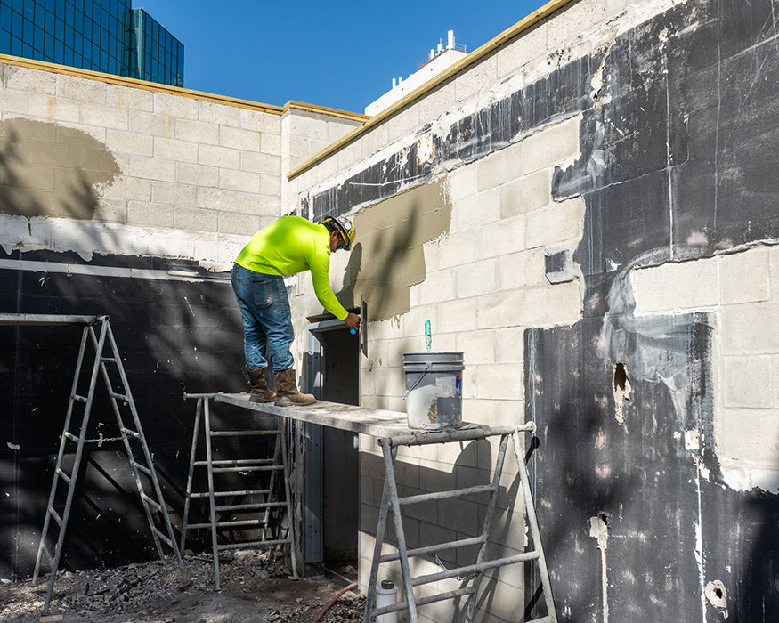 Worker applies stucco to rear wall.