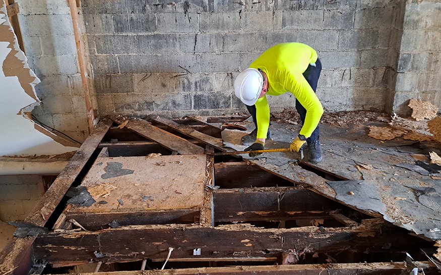 Workers remove mezzanine steel trusses.