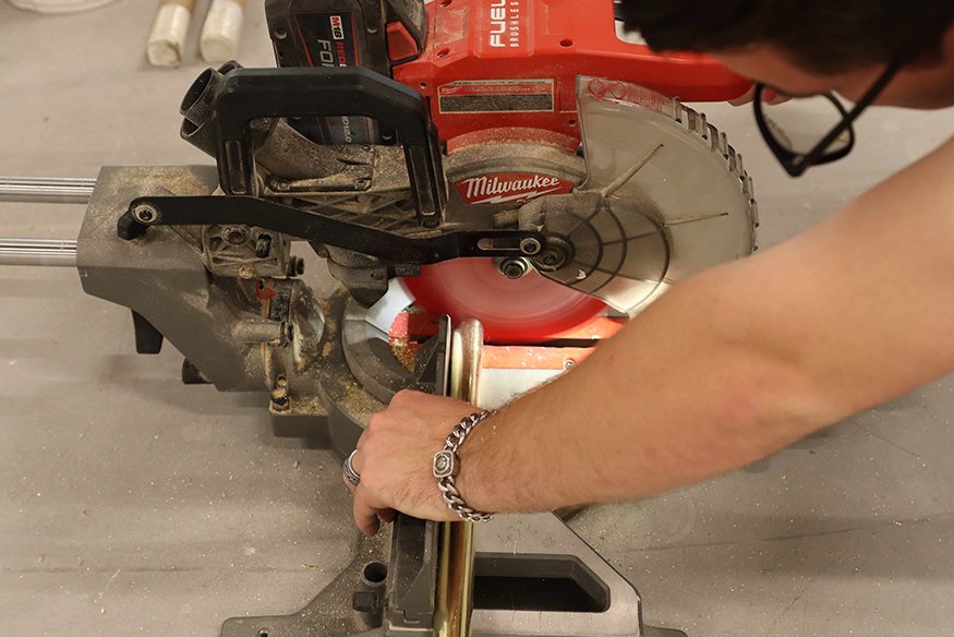 Miter saw cuts brass door bar.
