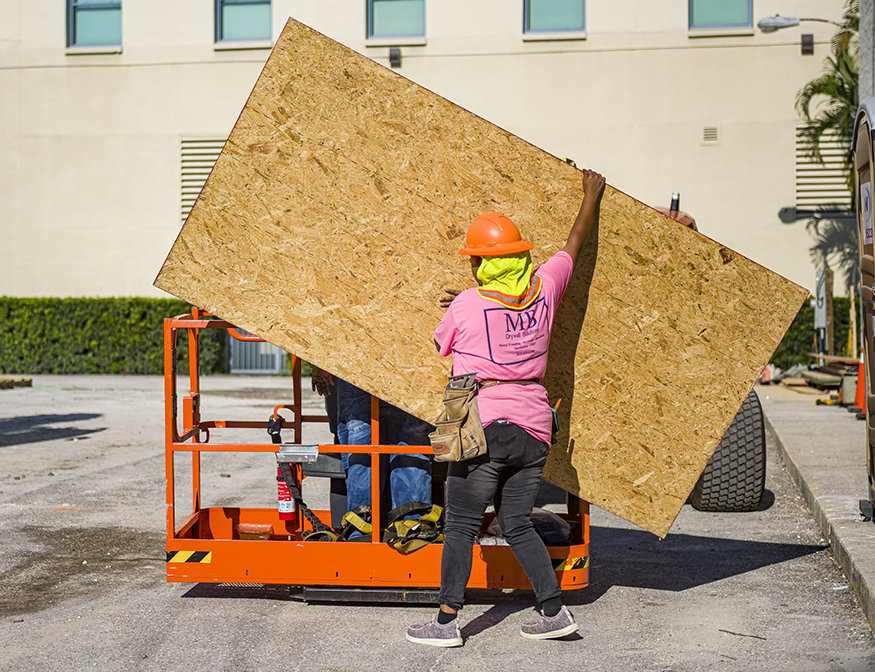 A wooden board is loaded on the crane.