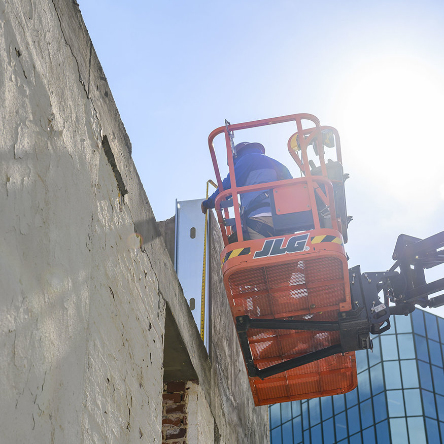 Workers measuring the parapet frame.