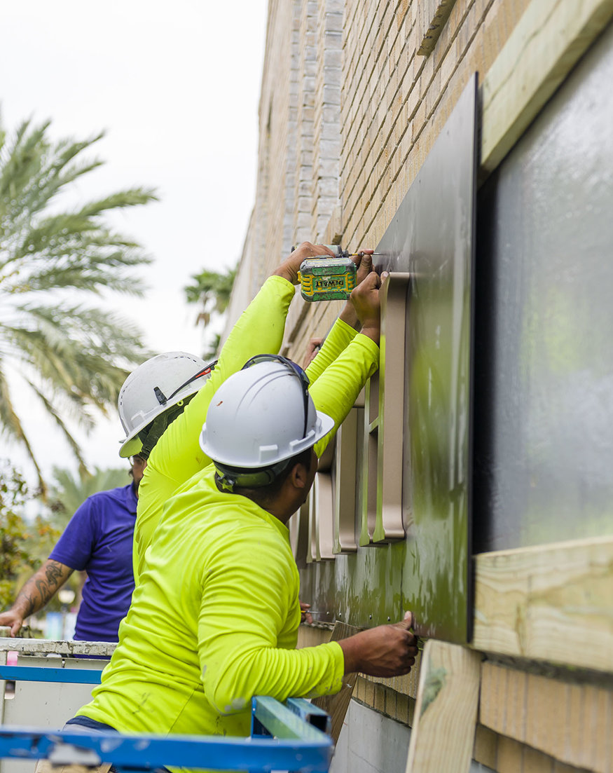 Workers installing Woolworth sign panels.