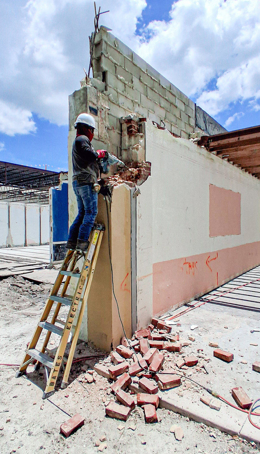 Worker removes masonry from front column.